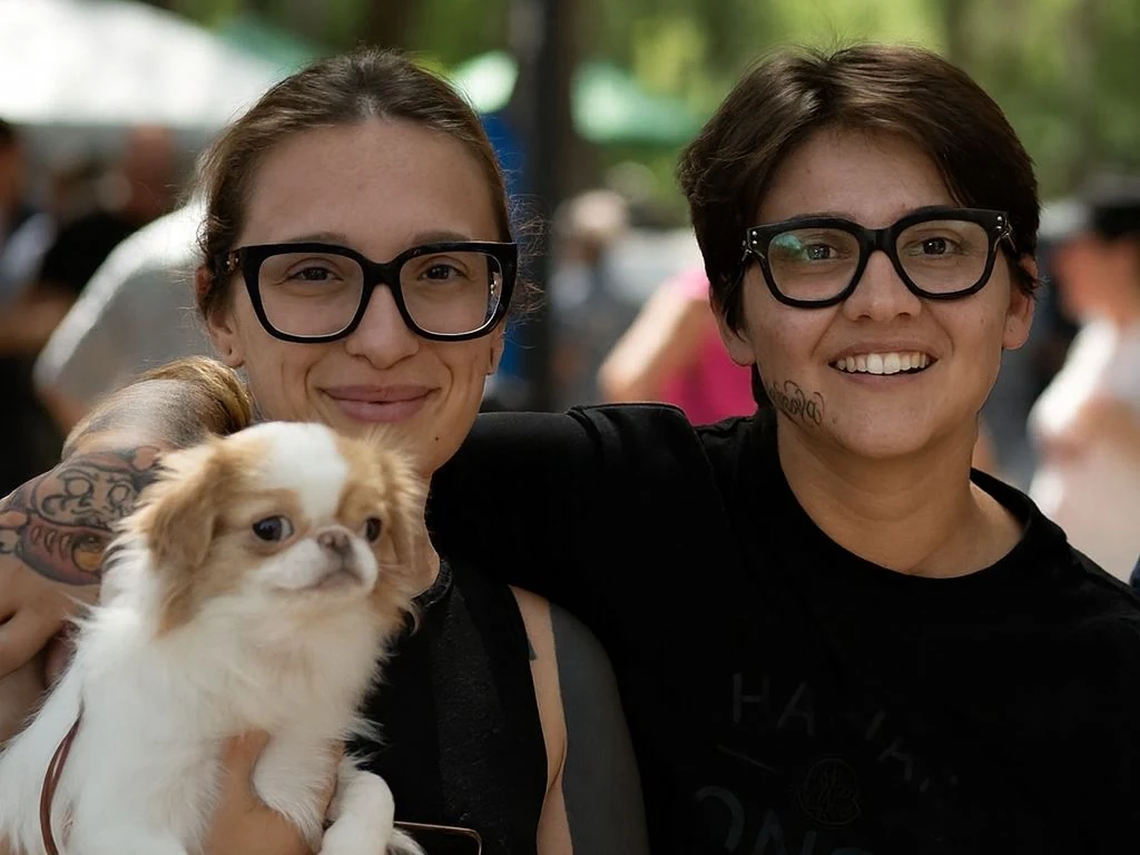 Due allevatrici posano con una Japanese Chin tra le braccia